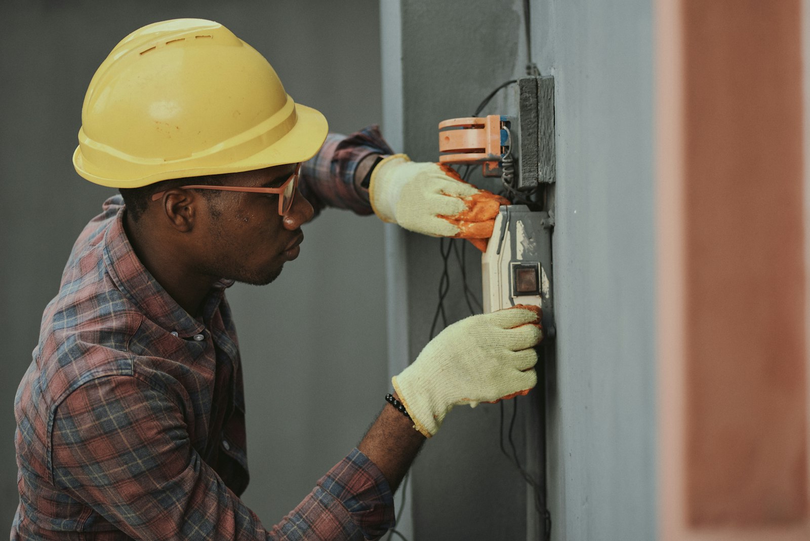 Technician in a hard hat servicing equipment on site