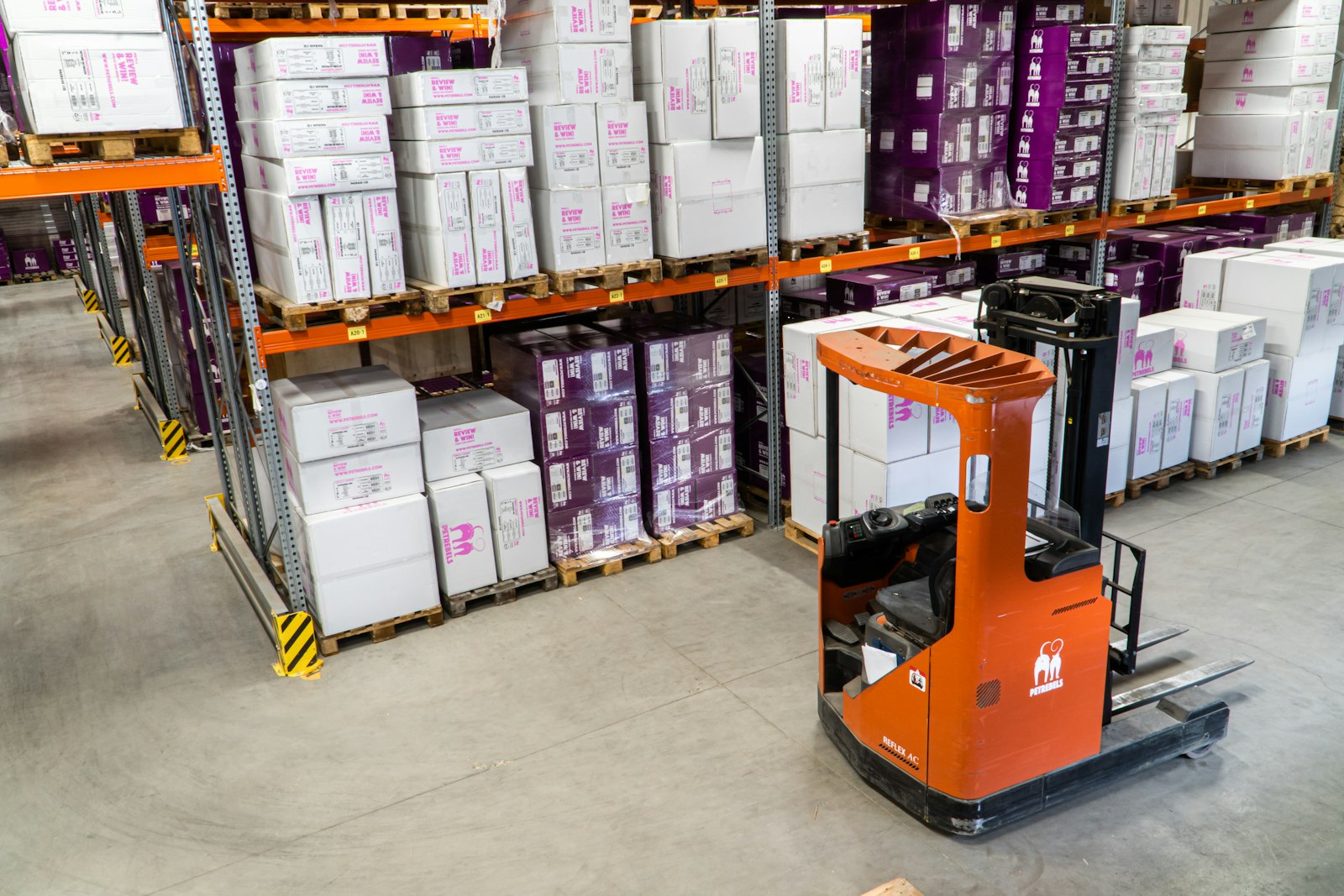 Warehouse racks with staged equipment beside a forklift